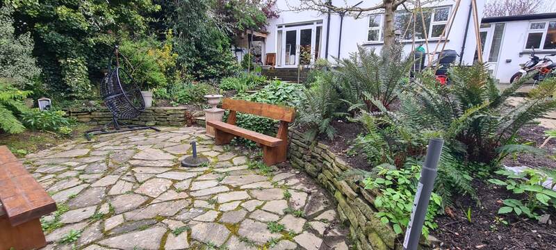 Timber garden bench set against a raised flower bed