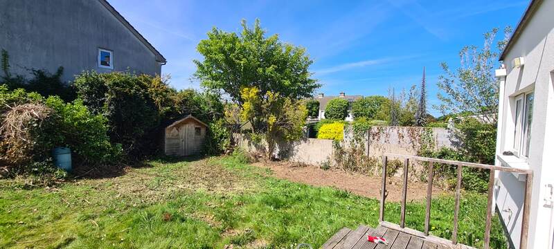 Same garden cleared back, open lawn and boundary wall visible