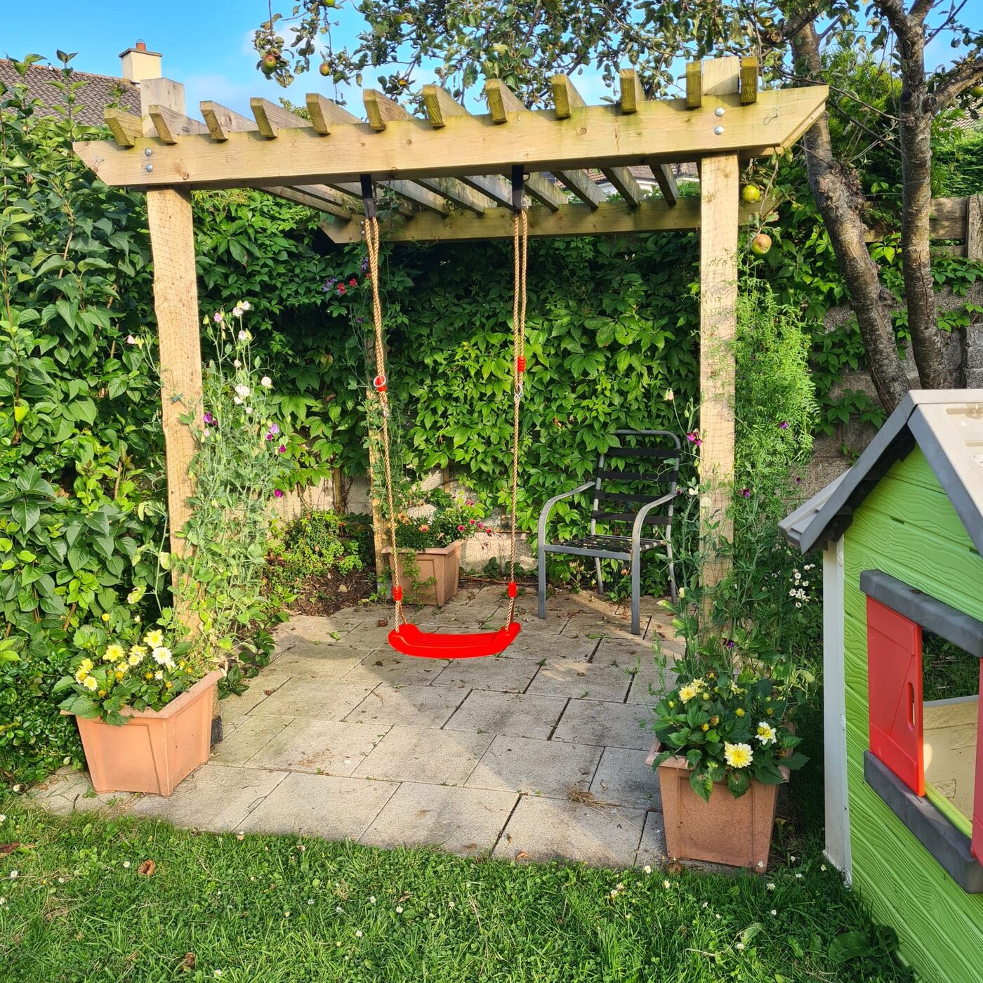 A garden pergola fitted with a child's swing