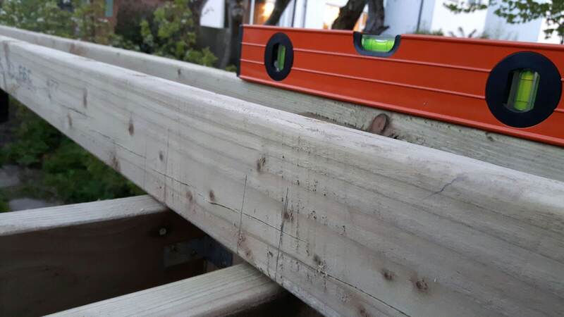 Checking the pergola beams for level with a spirit level