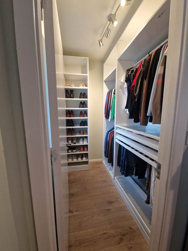 Finished walk-in wardrobe with fitted shelving, hanging rails and drawers